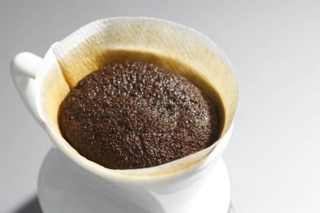 Photo for Pour over filter with ground coffee in the funnel in focus. Drip filter coffee brewing. - Royalty Free Image