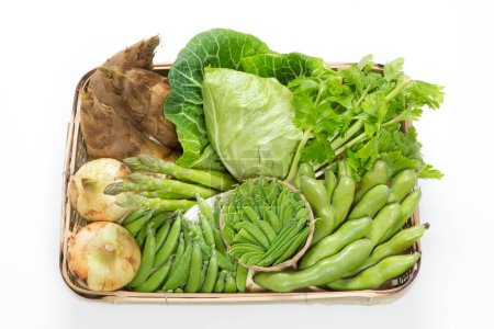 Photo for Fresh green organic vegetables in wooden box isolated on white background. Green peas, cabbage, herbs, onions, asparagus, bamboo sprouts - Royalty Free Image