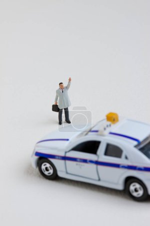 Photo for Miniature man standing and catching taxi car - Royalty Free Image