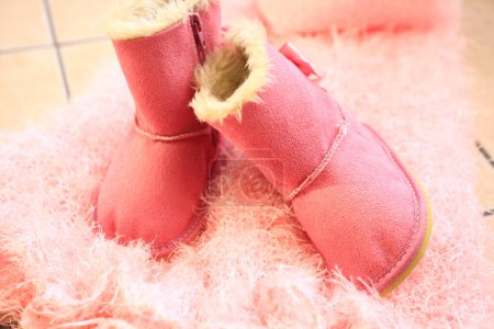 Photo for Pink ugg boots on cozy fluffy blanket - Royalty Free Image