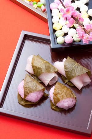 Téléchargez les photos : Sakuramochi - Gâteaux de riz sucré japonais "mochi" aux feuilles de sakura décorées de fleurs de sakura - en image libre de droit