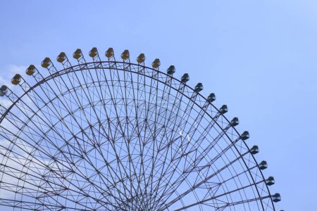 Téléchargez les photos : Ferris roue dans le parc d'attractions contre le ciel bleu - en image libre de droit
