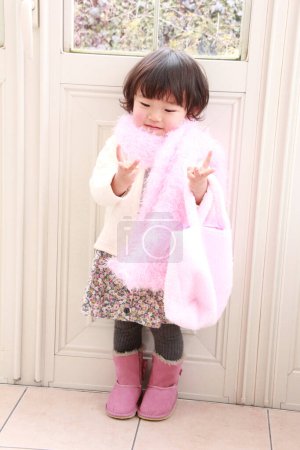 Photo for Cute Asian little girl wearing pink scarf at home - Royalty Free Image