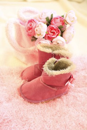 Photo for Pink ugg boots and flowers on cozy fur - Royalty Free Image