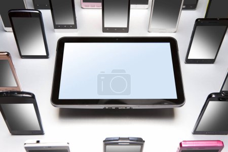 Foto de Vista de cerca de diferentes teléfonos inteligentes modernos y tabletas digitales sobre fondo gris. - Imagen libre de derechos