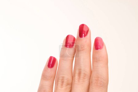 Téléchargez les photos : Main féminine avec manucure rouge sur fond blanc - en image libre de droit