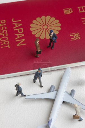 Foto de Miniatura personas figuras con avión de juguete y pasaporte japonés - Imagen libre de derechos