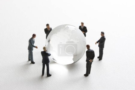 Foto de Gente de negocios en miniatura con globo de vidrio sobre fondo blanco. concepto de negocio internacional - Imagen libre de derechos
