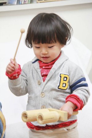 Téléchargez les photos : Portrait de mignonne petite fille asiatique avec jouet à la maison - en image libre de droit