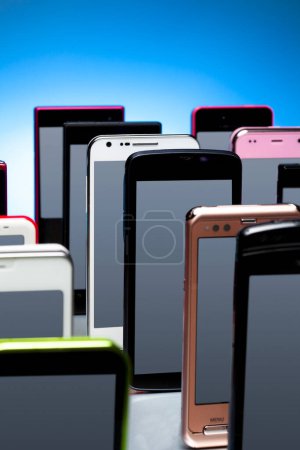 Téléchargez les photos : Gros plan des téléphones mobiles modernes sur fond bleu - en image libre de droit