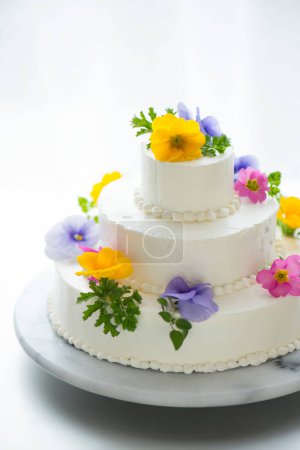 Photo for White wedding cake decorated with cream and fresh flowers. - Royalty Free Image