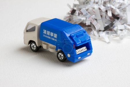 Foto de Modelo en miniatura de camión de basura azul y basura de papel - Imagen libre de derechos