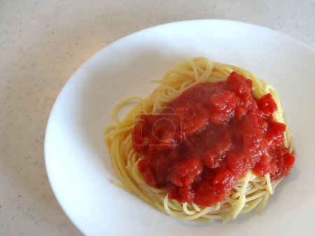 Téléchargez les photos : Vue rapprochée de délicieux spaghettis à la sauce tomate sur assiette blanche - en image libre de droit