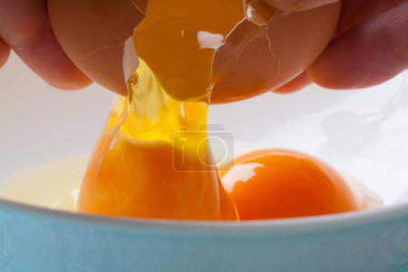Foto de Persona rompiendo huevos en el tazón - Imagen libre de derechos