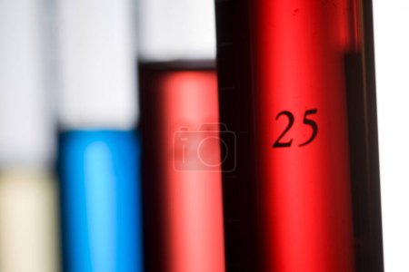 Photo for Close-up view of test tubes filled with colored liquids on white background - Royalty Free Image