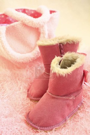 Photo for Pink ugg boots on cozy fluffy blanket - Royalty Free Image