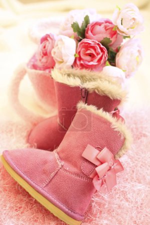 Photo for Pink ugg boots and flowers on cozy fur - Royalty Free Image