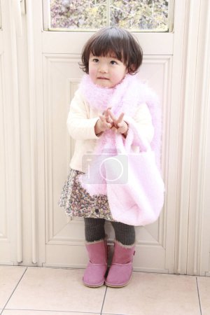 Photo for Cute Asian little girl wearing pink scarf at home - Royalty Free Image