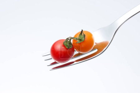Téléchargez les photos : Tomates rouges avec fourchette sur fond blanc - en image libre de droit