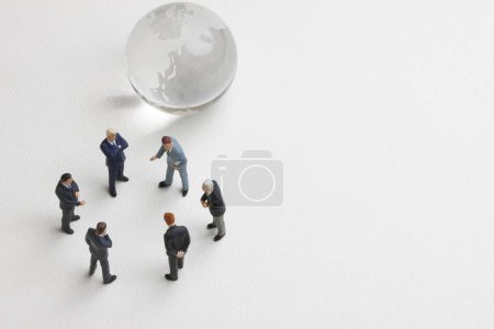 Téléchargez les photos : Hommes d'affaires miniatures avec globe sur fond blanc - en image libre de droit