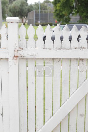 Photo for White metal fence and wooden gate in the yard - Royalty Free Image