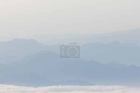 Téléchargez les photos : Brouillard matinal sur la chaîne de montagnes, belle scène du lever du soleil - en image libre de droit