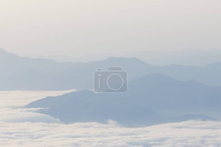 Téléchargez les photos : Brouillard matinal sur la chaîne de montagnes, belle scène du lever du soleil - en image libre de droit