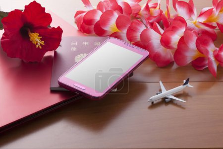 Foto de Japan passport, smartphone, red tropical flowers and toy plane. Travel and vacation concept - Imagen libre de derechos
