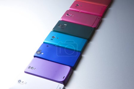 Téléchargez les photos : Vue rapprochée de différents téléphones mobiles modernes colorés sur fond gris - en image libre de droit