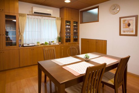 Téléchargez les photos : Cuisine avec armoires en bois et salle à manger dans une maison confortable - en image libre de droit
