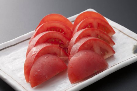 Photo for Close up view of fresh ripe sliced tomatoes on plate - Royalty Free Image