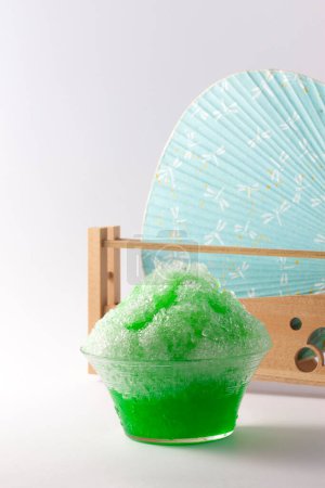 Photo for Cold shaved ice and fan on background, close up - Royalty Free Image