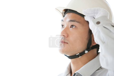 Téléchargez les photos : Travailleur japonais confiant dans la construction. jeune homme avec casque sur fond blanc - en image libre de droit