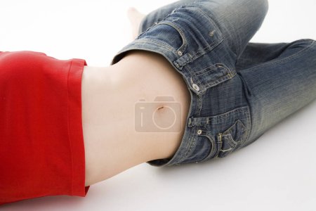 Téléchargez les photos : Photo recadrée de femme couchée sur le sol en haut rouge et jeans - en image libre de droit