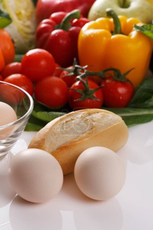 Téléchargez les photos : Une table avec œufs, pain, tomates et autres légumes - en image libre de droit
