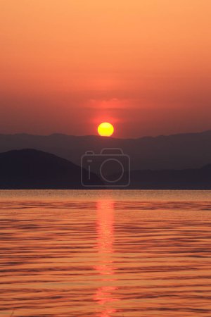 Photo for Beautiful sunset over the lake with hills on horizon - Royalty Free Image