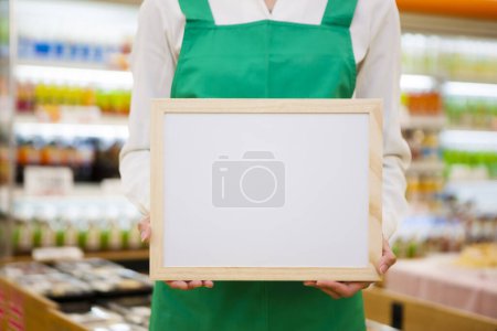 Foto de Primer plano de la hembra con pizarra blanca en blanco en el supermercado - Imagen libre de derechos