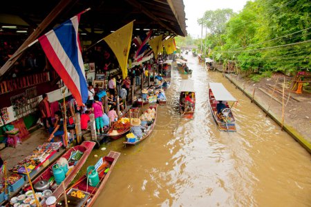 Photo for Local people sell fruits, food and souvenirs at famous tourist attraction Damnoen Saduak floating market - Royalty Free Image