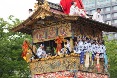 Foto de Festival Gion Matsuri, Procesión Yamaboko Junko. Gente tirando de la gran carroza tradicional de madera desfile en la calle de la ciudad - Imagen libre de derechos