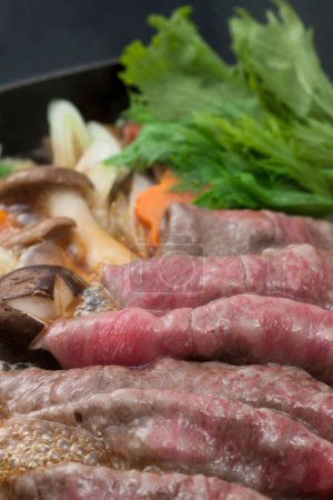 Photo for Sukiyaki, Japanese hot pot dish of beef, vegetables and tofu simmered in sweet sauce - Royalty Free Image