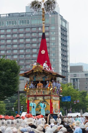 Téléchargez les photos : Festival Gion Matsuri, Procession Yamaboko Junko. Les gens tirant le grand défilé de flotteurs traditionnels en bois dans la rue de la ville - en image libre de droit