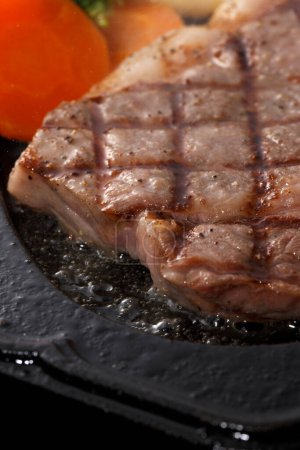 Téléchargez les photos : Vue rapprochée de délicieux steak grillé sur fond noir - en image libre de droit