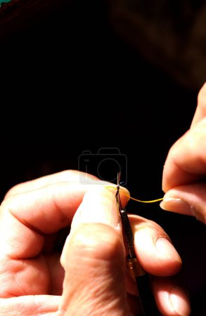 man's hands tieing fly fishing line