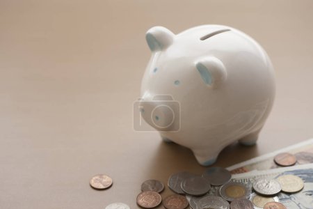 Photo for Piggy bank, banknotes and coins on wooden table - Royalty Free Image