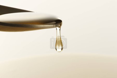 Photo for Tasty pouring honey  in spoon on background, close up - Royalty Free Image
