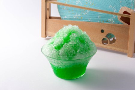 Photo for Cold shaved ice and fan on background, close up - Royalty Free Image