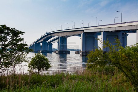 Téléchargez les photos : Pont sur la rivière avec ciel bleu et bâtiments sur le fond - en image libre de droit