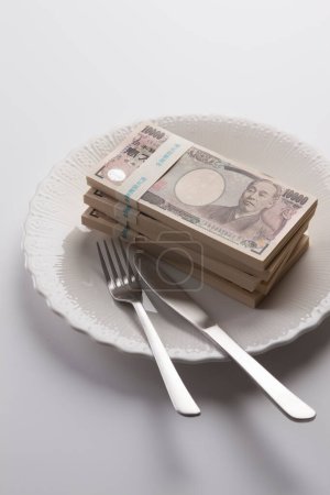 Foto de Un plato de dinero japonés, billetes de yen con tenedor y cuchillo - Imagen libre de derechos