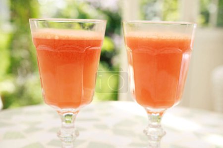 Téléchargez les photos : Jus de carotte frais dans des verres sur le fond, gros plan - en image libre de droit