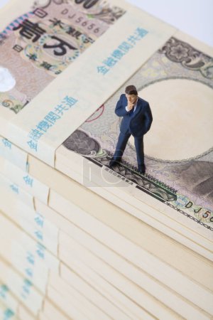 Téléchargez les photos : Businessman standing on Japanese yen banknotes. - en image libre de droit